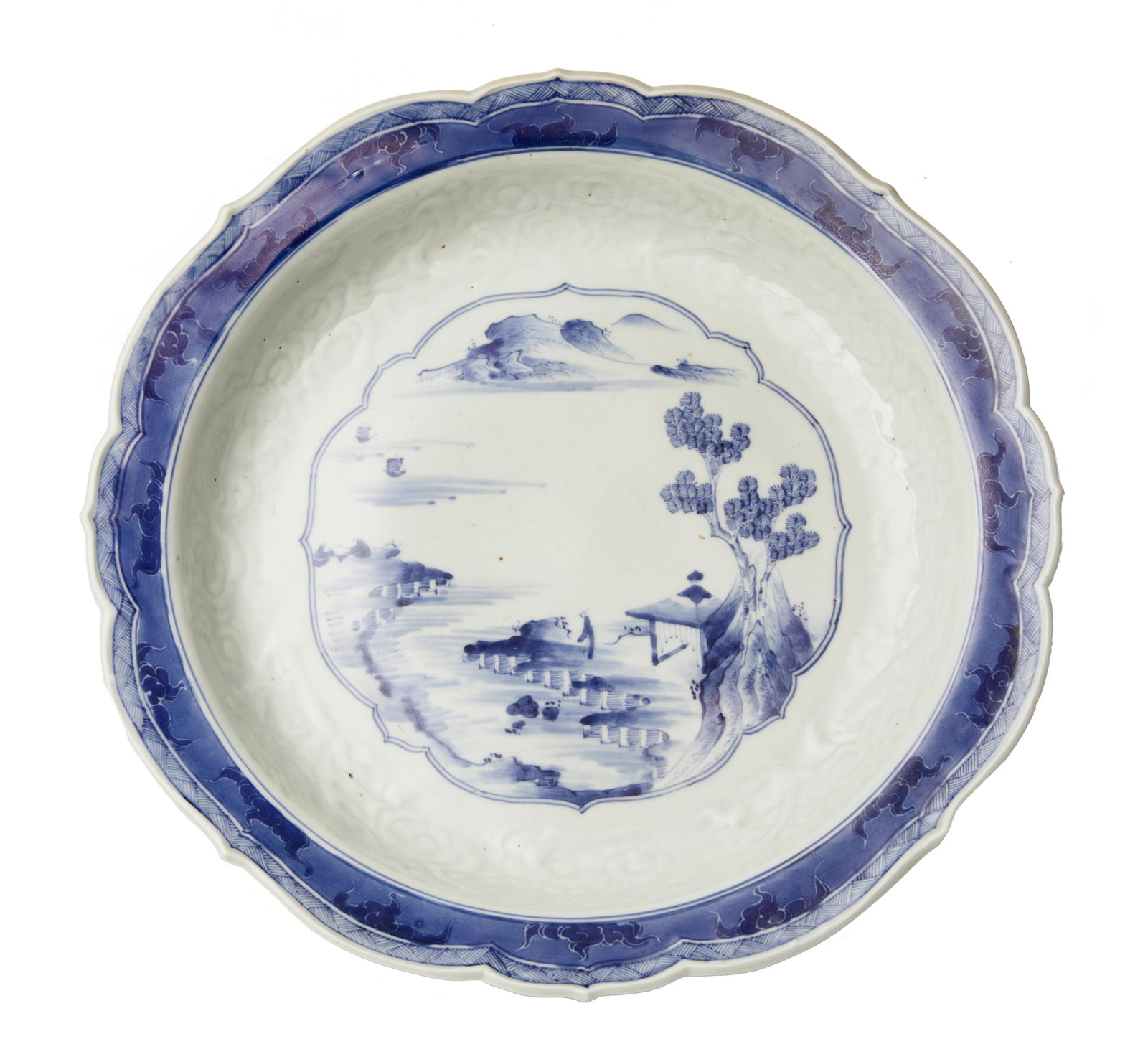 AN ARITA BLUE-AND-WHITE PORCELAIN BOWL Edo period (1615-1868), 19th century: AN ARITA BLUE-AND-WHITE PORCELAIN BOWL Edo period (1615-1868), 19th century The bowl with foliate rim, the body molded with cloud motifs, the central lobed underglaze-blue roundel with a Chinese-style