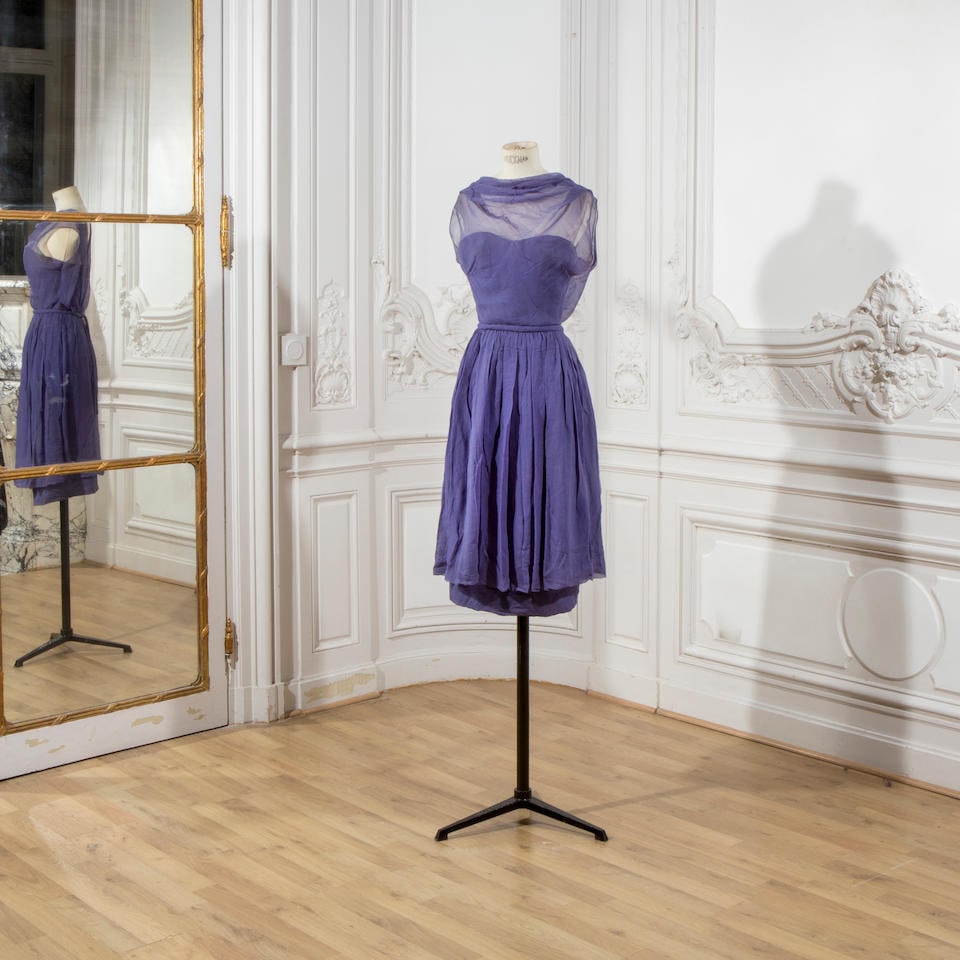 Guy LAROCHE, collection Haute Couture, circa 1960. Robe de cocktail en mousseline de soie lavande.: Guy LAROCHE, collection Haute Couture, circa 1960. Robe de cocktail en mousseline de soie lavande. Haut bustier sur dos nu recouvert d'un voile, jupe à deux niveaux à lien boudin. Griffe bla