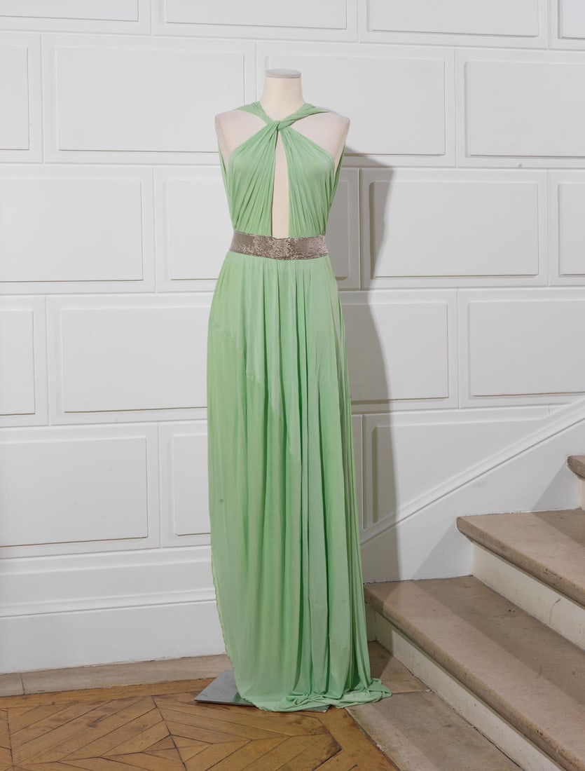 Guy LAROCHE Couture. Robe longue jersey verte.: Guy LAROCHE Couture. Robe longue jersey verte. Important décolleté croisé sur le devant, se terminant sur une ceinture de perles métallisées, jupe longue. Griffe noire, graphi