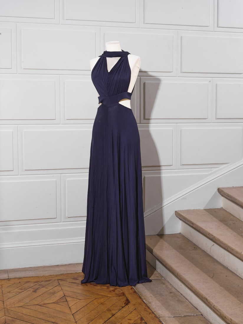 Guy LAROCHE Collection. Robe longue jersey marine.: Guy LAROCHE Collection. Robe longue jersey marine. Découpes à partir de la taille, décolleté en V, dos nu. Griffe blanche, graphisme noir. Footnotes: Guy LAROCHE Collection. Long n