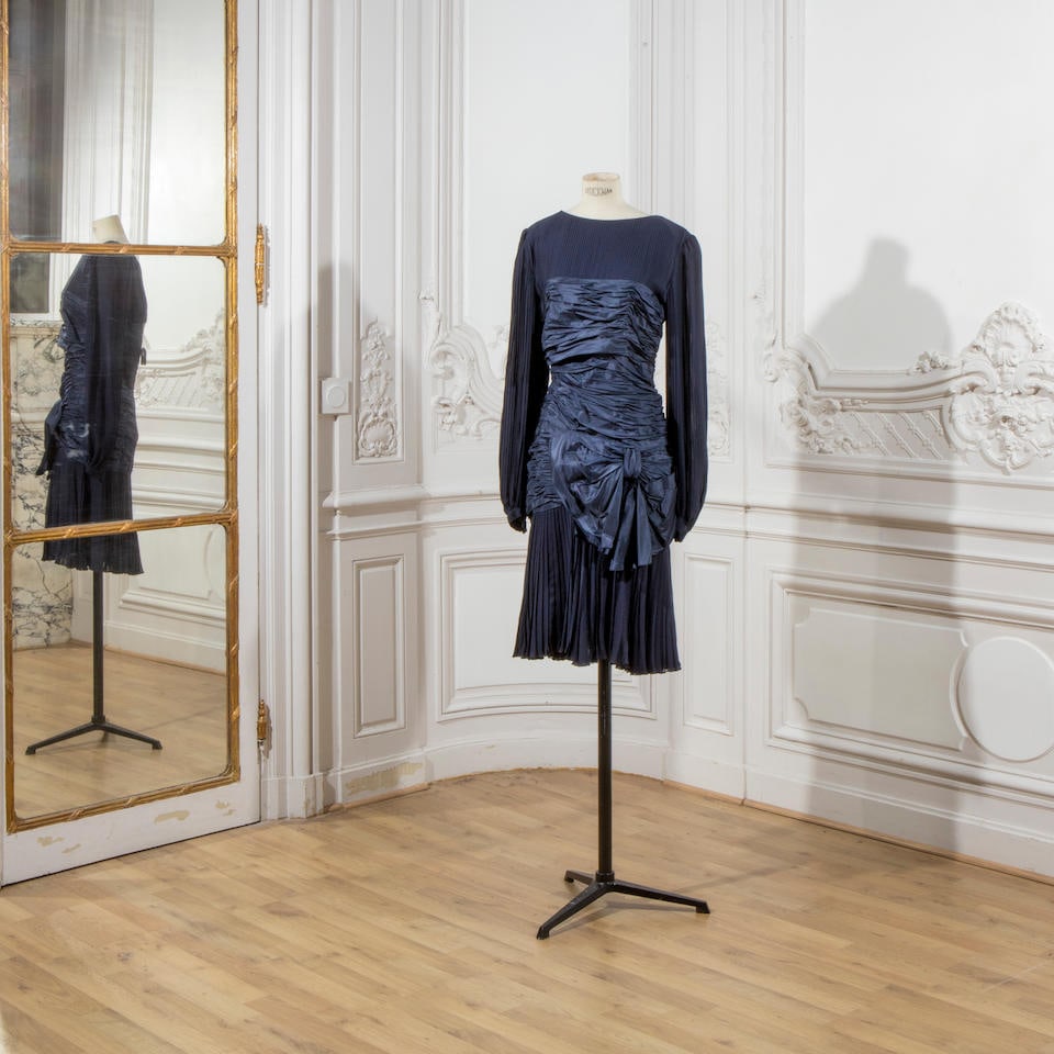 Guy LAROCHE, collection Haute Couture, circa 1980. Robe en soie bleu marine.: Guy LAROCHE, collection Haute Couture, circa 1980. Robe en soie bleu marine. En soie plissée, hanches surmontées d'un important nœud. Griffe blanche, graphisme noir. Footnotes: Guy LARO