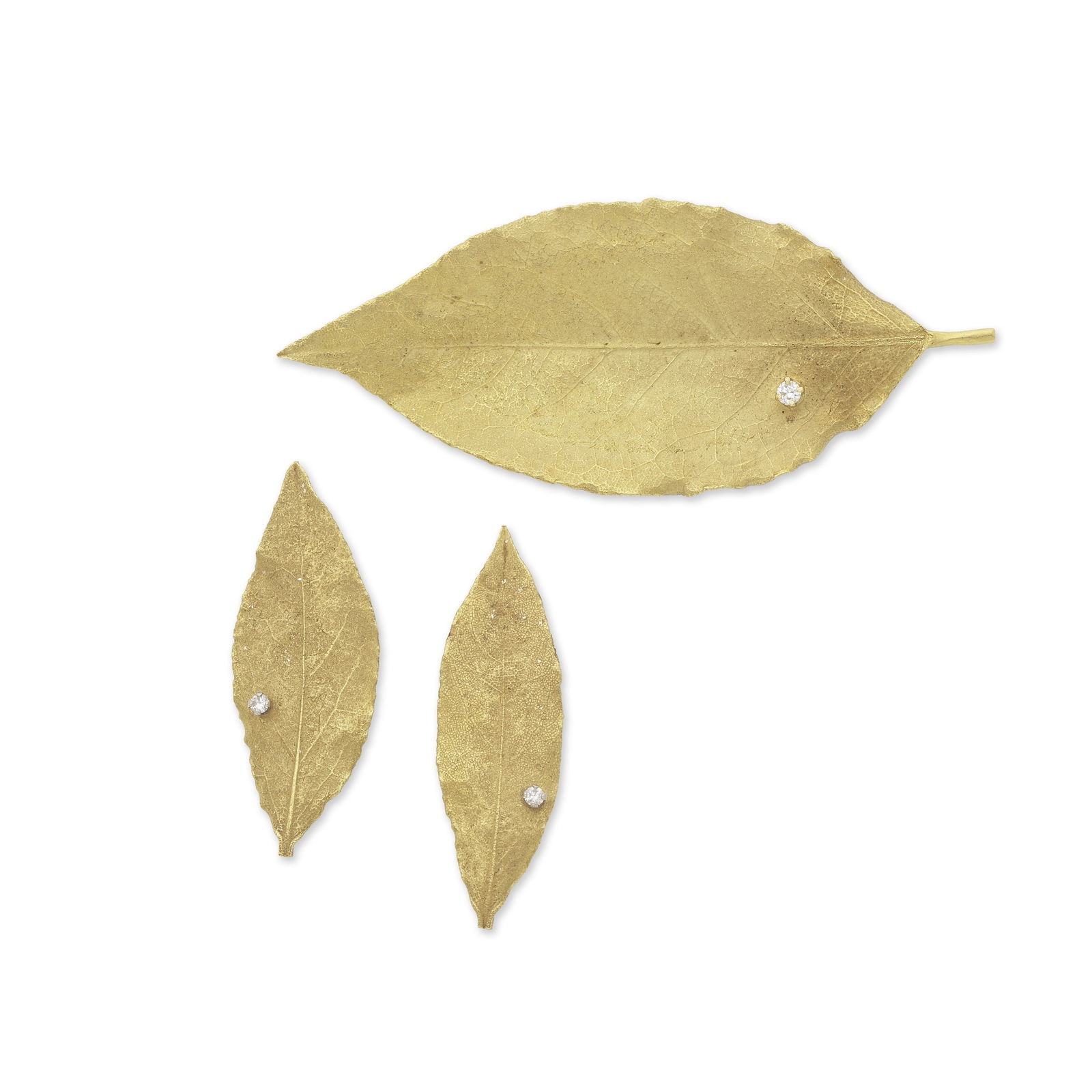 GRIMA: DEMI-PARURE OR, CIRCA 1980: GRIMA: DEMI-PARURE OR, CIRCA 1980 Comprenant une paire de clips d'oreilles et une broche formant trois feuilles de laurier, chacune sertie d'un diamant de taille brillant, signée Grima, poinç