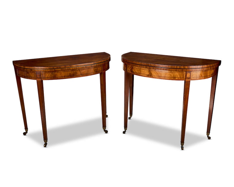 A pair of George III mahogany, crossbanded and ebonised line inlaid demi-lune card and tea table...: A pair of George III mahogany, crossbanded and ebonised line inlaid demi-lune card and tea tables Last quarter 18th century The hinged fold-over tops, one enclosing a veneered surface and the other a