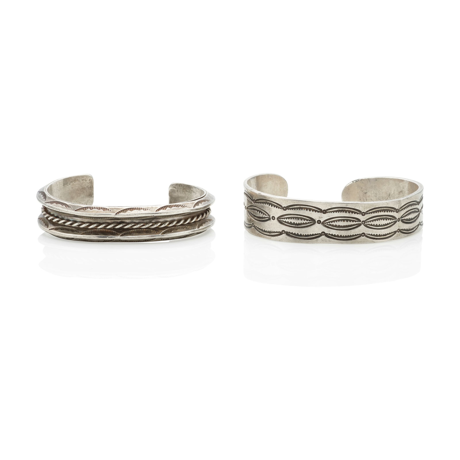 Two Diné (Navajo) cuff bracelets: Two Diné (Navajo) cuff bracelets The first a simple cuff with stamped designs, the second of stamped carinated and twisted wire construction. the first: inner circumference (including gap) 6 5/8i