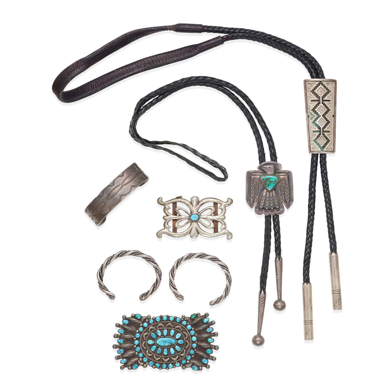 A group of Diné (Navajo) or Zuni jewelry: A group of Diné (Navajo) or Zuni jewelry Each of silver, including: three cuff bracelets (two of twisted wire, one stamped); two bolo ties (one thunderbird motif set with turquoise signed: Begay;