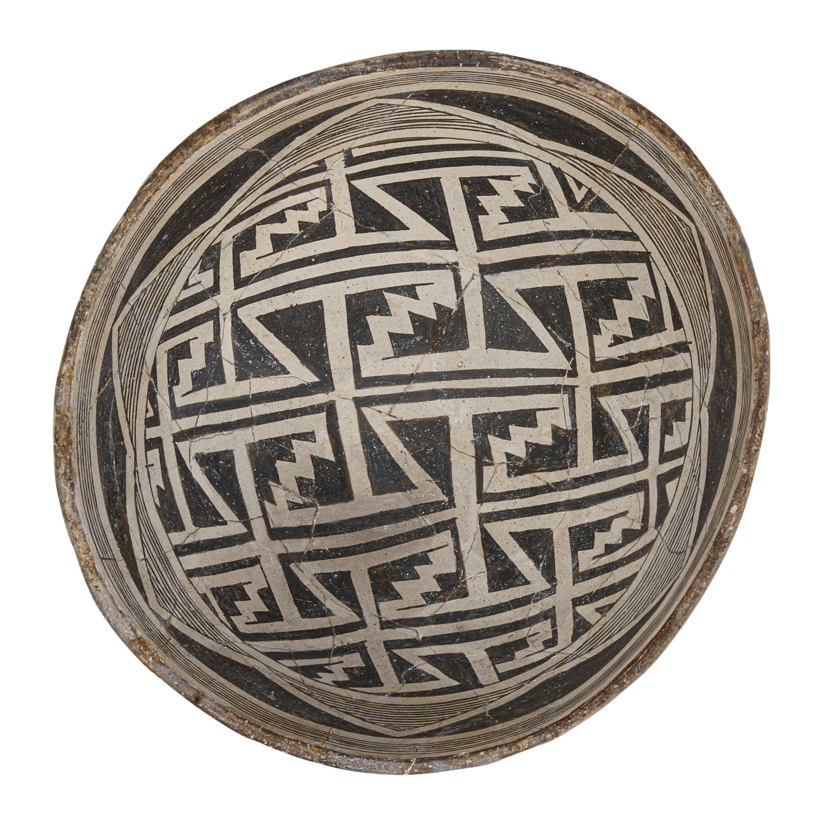 A Mimbres black-on-white bowl: A Mimbres black-on-white bowl The entire interior worked with interlocking meanders and fine-line triangles on a negative ground, the rim banded, restored. height 5in, width 10 1/4in Footnotes: Ink co