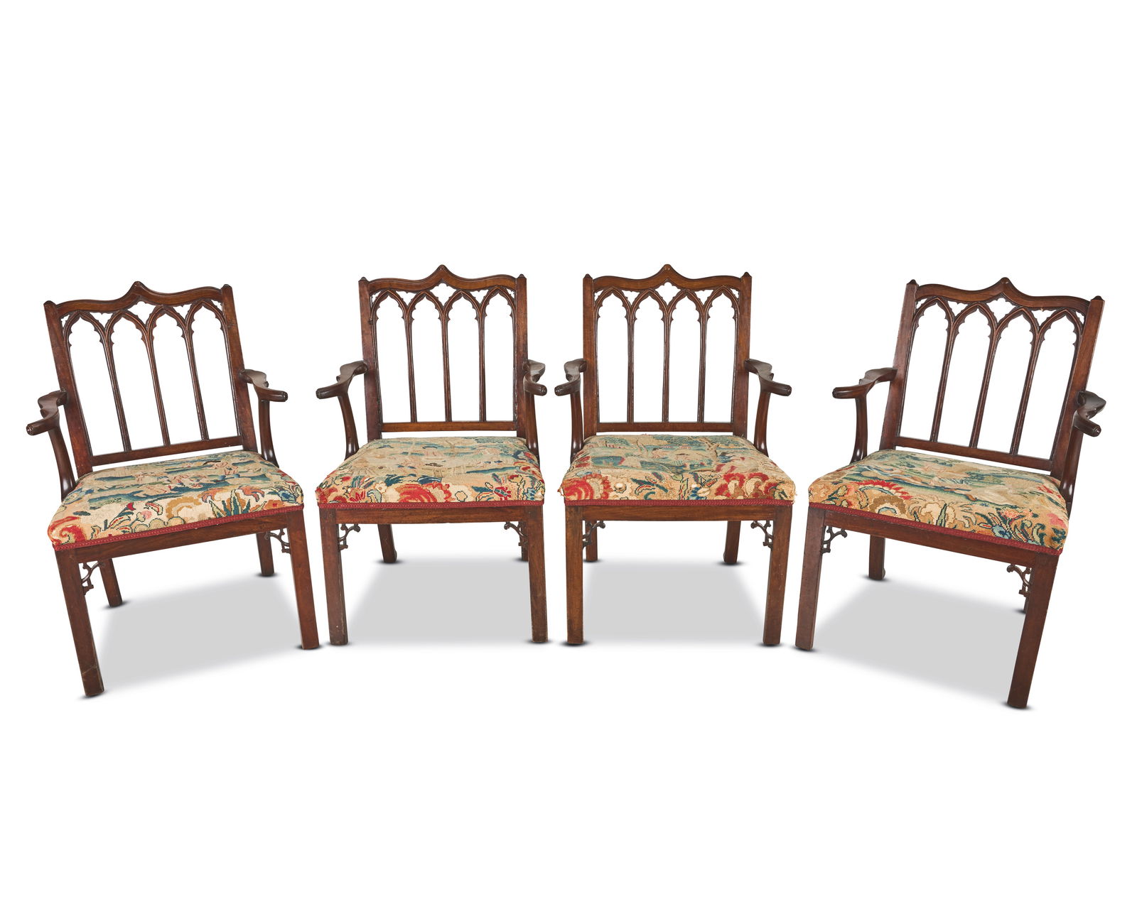 A set of four George III 'Gothick' mahogany open armchairs After a design by Thomas Chippendale ...: A set of four George III 'Gothick' mahogany open armchairs After a design by Thomas Chippendale and after designs by Robert Manwaring, with restorations Each with a square back and channelled pointed