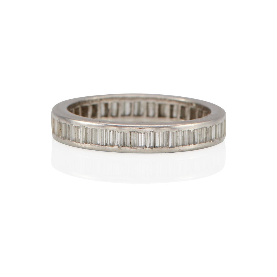 A WHITE METAL AND DIAMOND ETERNITY BAND: A WHITE METAL AND DIAMOND ETERNITY BAND • Platinum and palladium • Numerous baguette-shaped diamonds weighing approximately 1.60 carats • Size 5 • Estimated gross weight: 2.7 g