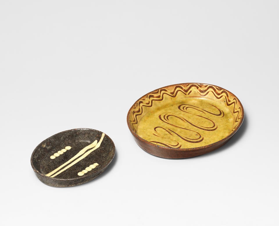 Michael Cardew Dish, circa 1938: Michael Cardew Dish, circa 1938 Earthenware, white slip with finger-wiped 'river' design in well and around rim, beneath an amber glaze. Together with a smaller dish, earthenware, dark brown glaze wit