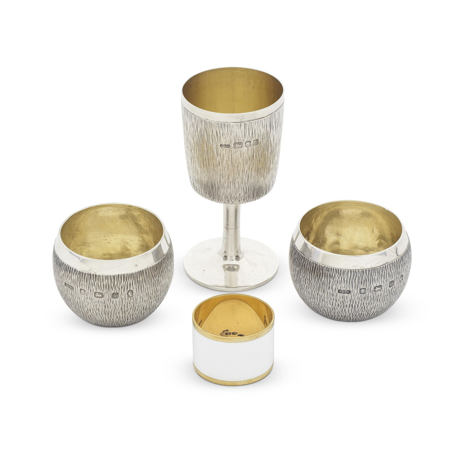 GERALD BENNEY: a pair of silver tumblers, a small silver goblet, and a silver-gilt and enamelled...: GERALD BENNEY: a pair of silver tumblers, a small silver goblet, and a silver-gilt and enamelled napkin ring London 1977, London 1975, and London 1972 The pair of tumblers, London 1977, also stamped