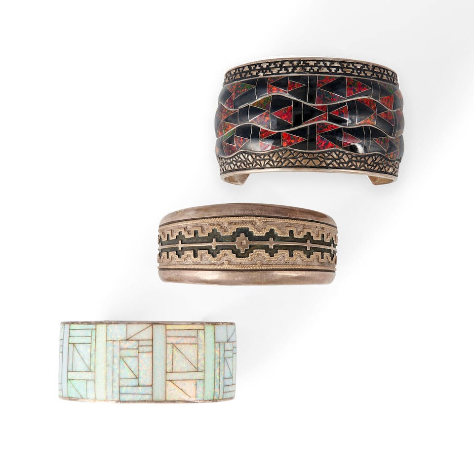 Three Southwest cuff bracelets interior circumference 5 3/4, with 1 3/4 gap, interior circumfere...: Three Southwest cuff bracelets A wide silver cuff marked 'GL .925,' a silver cuff with chip shell inlay marked, 'JLS,' and a silver cuff with overlay rug design, marked, 'D.A. Jackson,' for Dan Jackso
