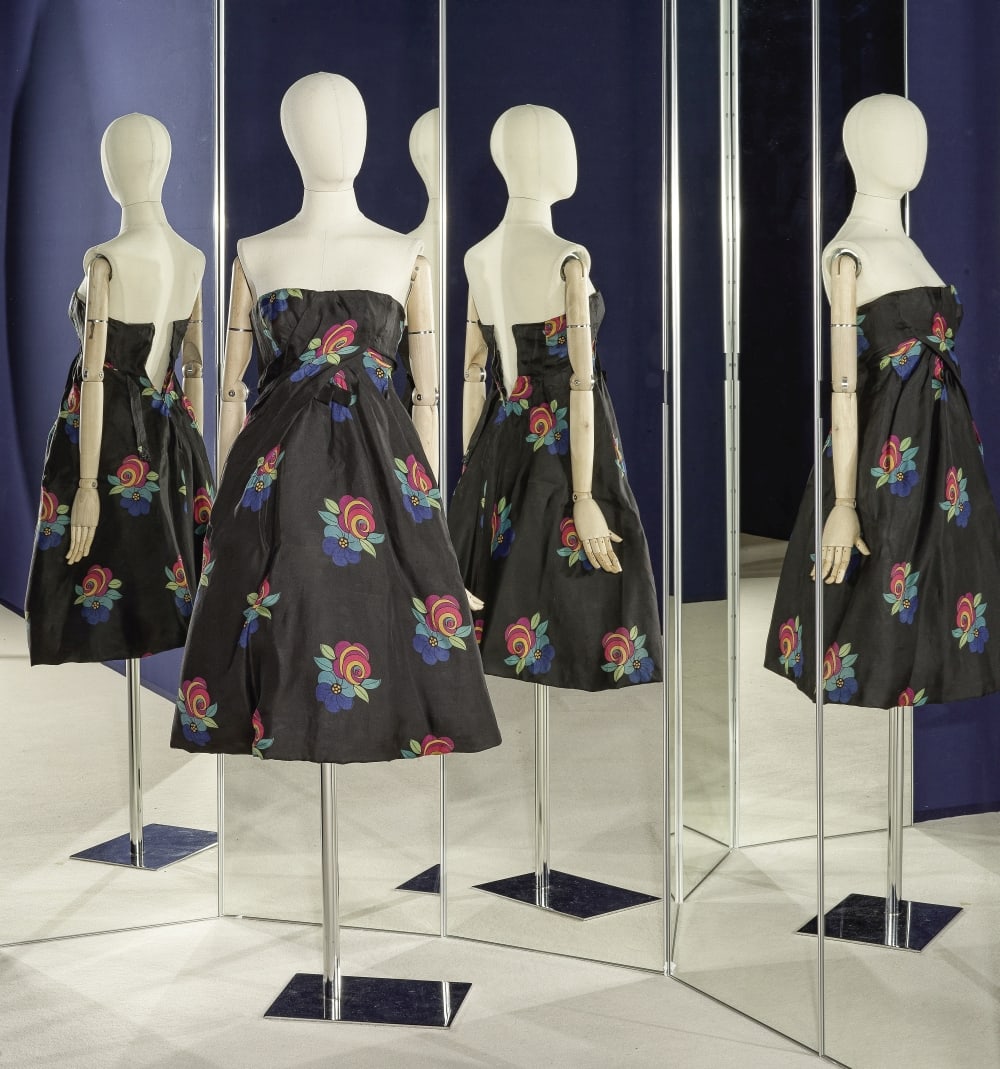 GUY LAROCHE, collection Haute Couture, circa 1958. Robe de cocktail en soie noire imprimée ...: GUY LAROCHE, collection Haute Couture, circa 1958. Robe de cocktail en soie noire imprimée de fleurs. Haut bustier drapé formant taille haute, jupe ample à plis en diagonal souligné