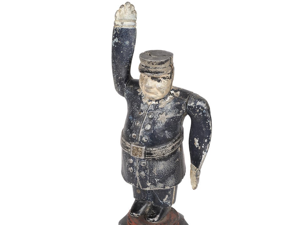 Sheriff: Sheriff Cast aluminium mascot, painted white and blue. Reference PAT-PDG, American origin, circa 1925. Movable arms that rotate with the wind. Mounted on a radiator cap. Height: 15.5 cm. Footnotes: Sh
