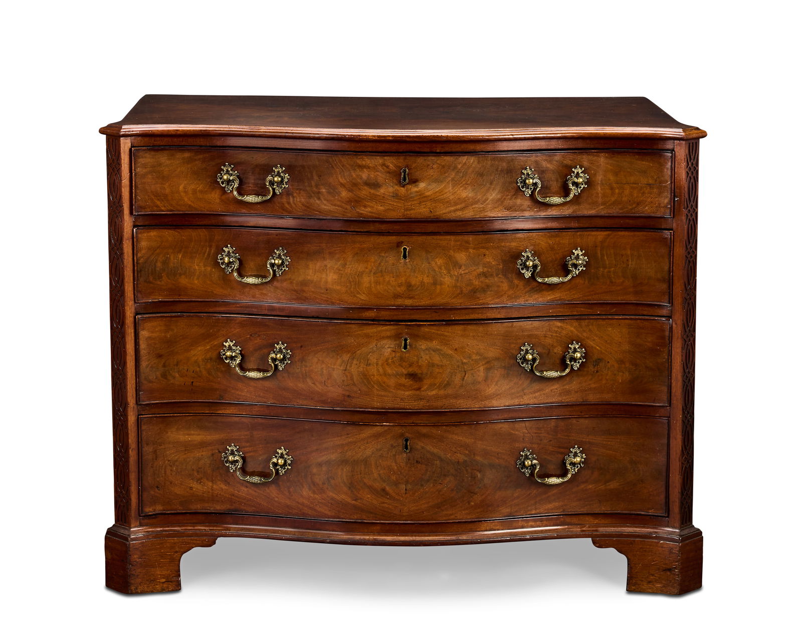 A George III mahogany serpentine commode Circa 1770, in the manner of Thomas Chippendale: A George III mahogany serpentine commode Circa 1770, in the manner of Thomas Chippendale The quarter veneered top with a cavetto moulded edge, above four long graduated drawers, the uppermost mahogany