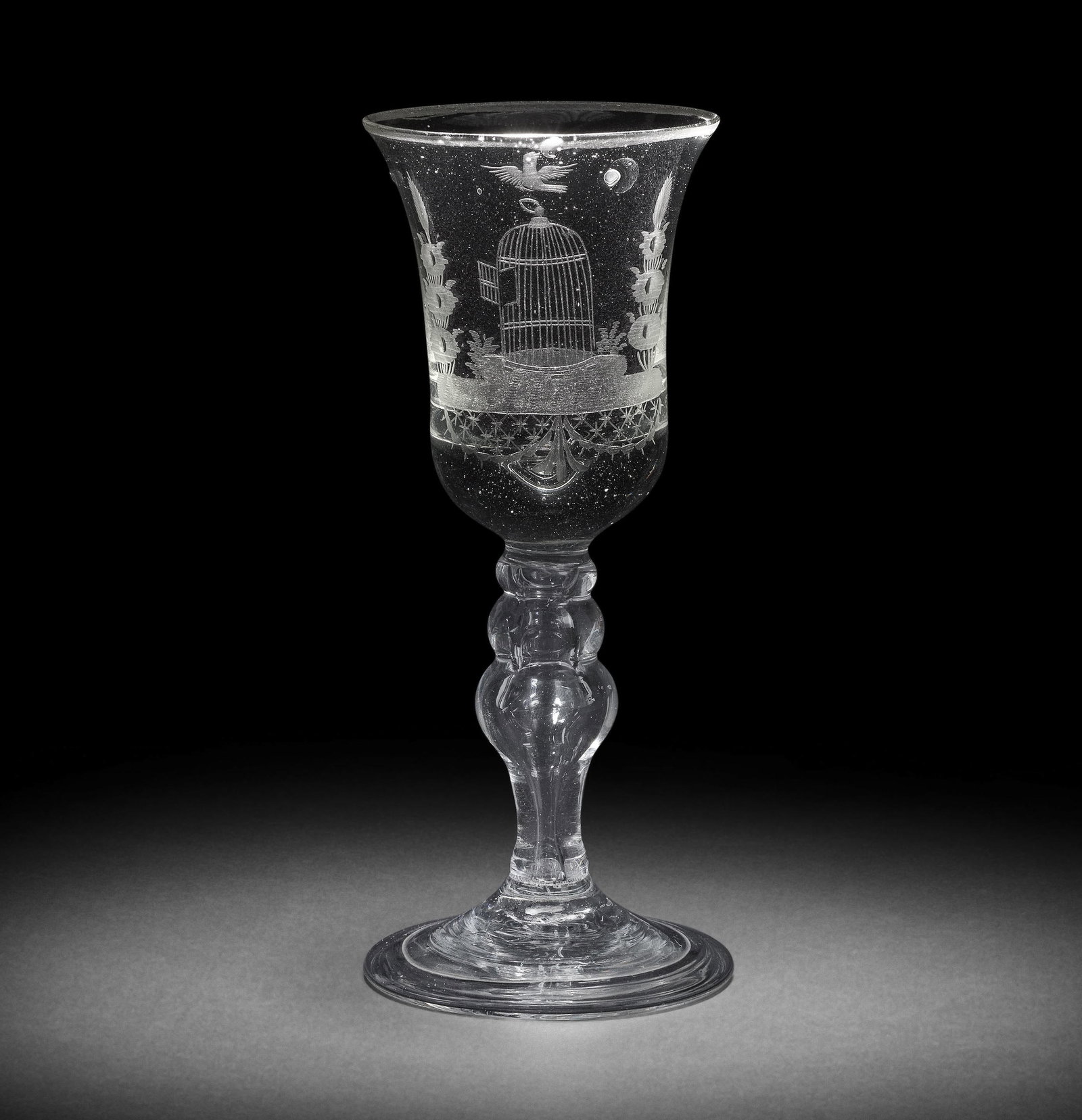 A Dutch engraved 'Liberty' baluster wine glass, mid-18th century: A Dutch engraved 'Liberty' baluster wine glass, mid-18th century The glass German, the bell bowl with a solid base, decorated with an open birdcage flanked by stylised plants, a bird in flight above, 