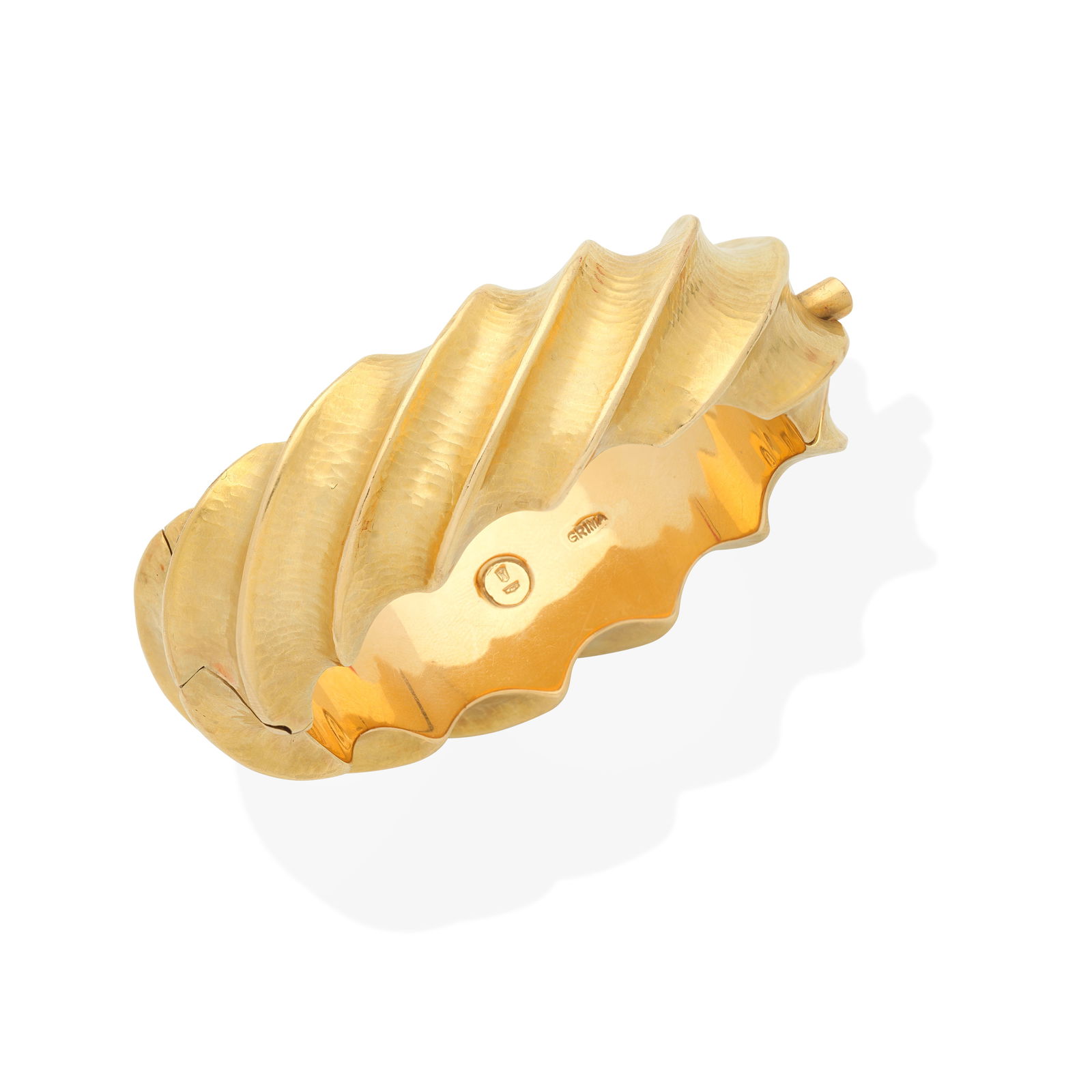 GRIMA: BANGLE,: GRIMA: BANGLE, CIRCA 1995 Of fluted form and hammered finish, signed Grima, inner circumference 17.0cm, maker's pouch Footnotes: Lots 110 - 113: A Private UK Collection of Grima Jewellery Saleroom not