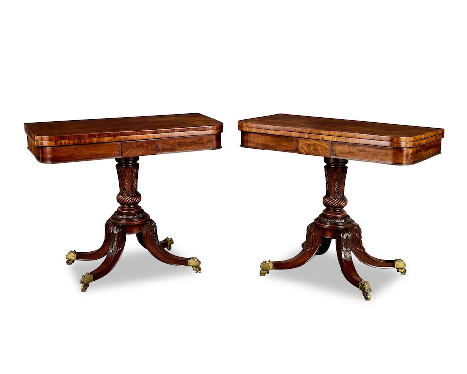 A pair of George IV plum pudding mahogany and mahogany tea tables Circa 1825, probably Scottish (2): A pair of George IV plum pudding mahogany and mahogany tea tables Circa 1825, probably Scottish Each with a rounded rectangular swivel hinged top, on an acanthus clasped ring turned baluster column wi