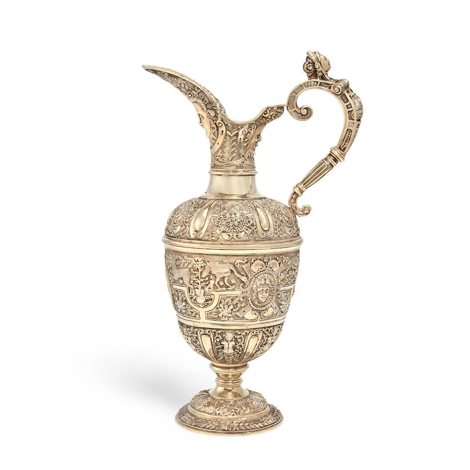 A Victorian silver gilt 'Cellini' ewer George Fox, London 1876: A Victorian silver gilt 'Cellini' ewer George Fox, London 1876 Conventional ovoid form, hinged cover and cast scroll handle formed as a woman's bust, the body profusely chased and embossed with classi