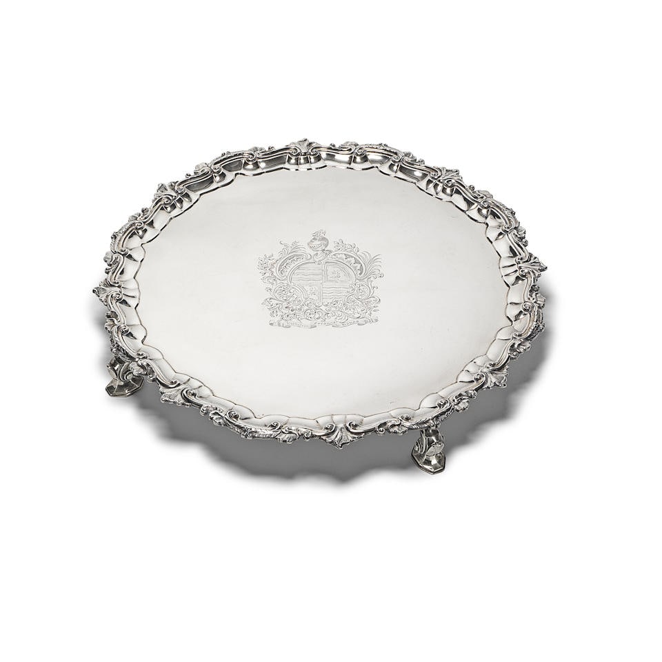 An Irish George III silver salver Robert Calderwood, Dublin, circa 1760: An Irish George III silver salver Robert Calderwood, Dublin, circa 1760 On four scroll and pad feet and with moulded scroll and foliate rim, engraved with a coat of arms, diameter 40cm, weight 64.5oz