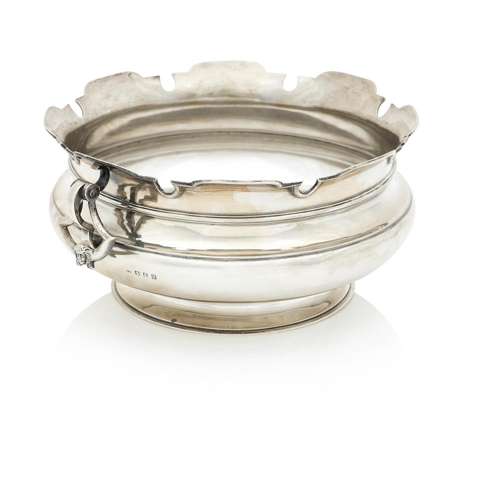 An Edwardian silver monteith bowl By John Alexander Fettes, Glasgow, 1902: An Edwardian silver monteith bowl By John Alexander Fettes, Glasgow, 1902 Of compressed circular form with twin drop handles decorated with masks and shaped rim, height 13cm, diameter 26.5cm, weight