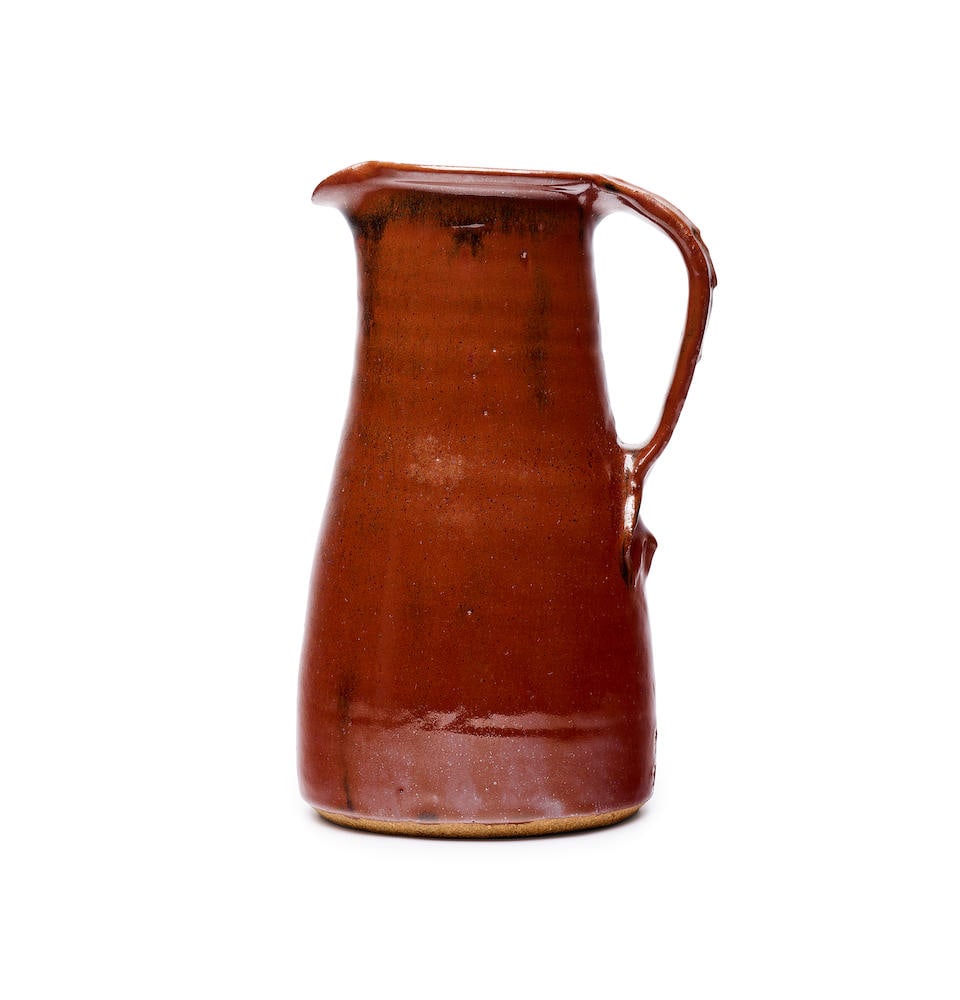 Bernard Leach (British, 1887-1979) A stoneware pitcher height: 25.5cm: Bernard Leach (British, 1887-1979) A stoneware pitcher impressed with potter and pottery seals with brown tenmoku glaze, decorated with soft horizontal bands to the body, raised decoration on the hand