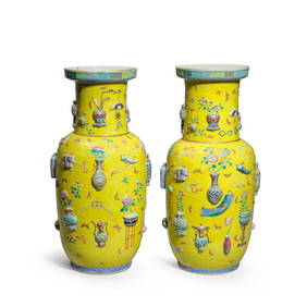 A NEAR PAIR OF MOULDED FAMILLE ROSE YELLOW GROUND 'HUNDRED ANTIQUES' VASES 19th century (2) (1 of 2)