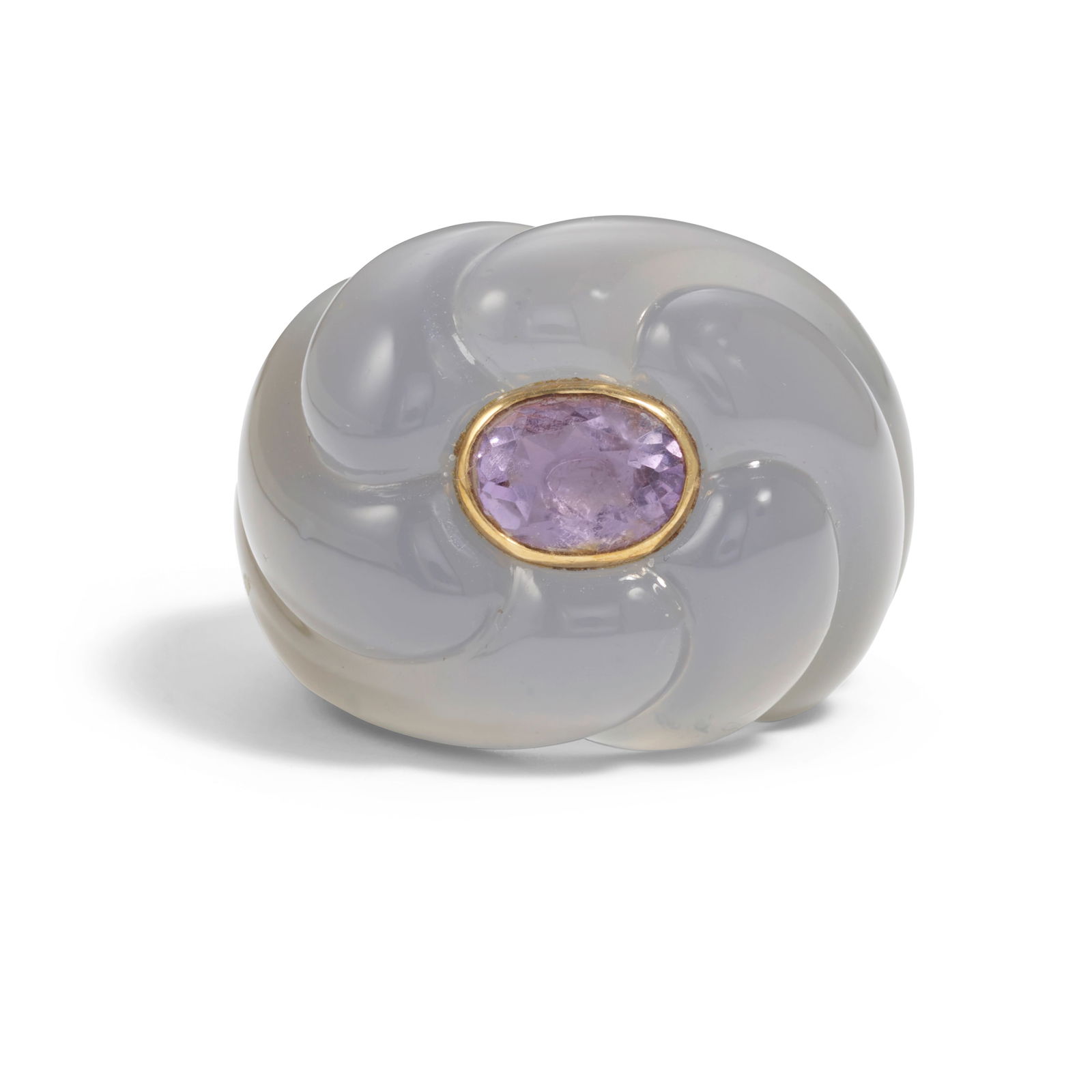 SUZANNE BELPERRON: AN 18K GOLD, CHALCEDONY AND AMETHYST RING, CIRCA 1945: SUZANNE BELPERRON: AN 18K GOLD, CHALCEDONY AND AMETHYST RING, CIRCA 1945 Composed of carved chalcedony of fluted tourbillon design around a bezel-set oval-cut amethyst, unsigned, size 6 Footnotes: Acc