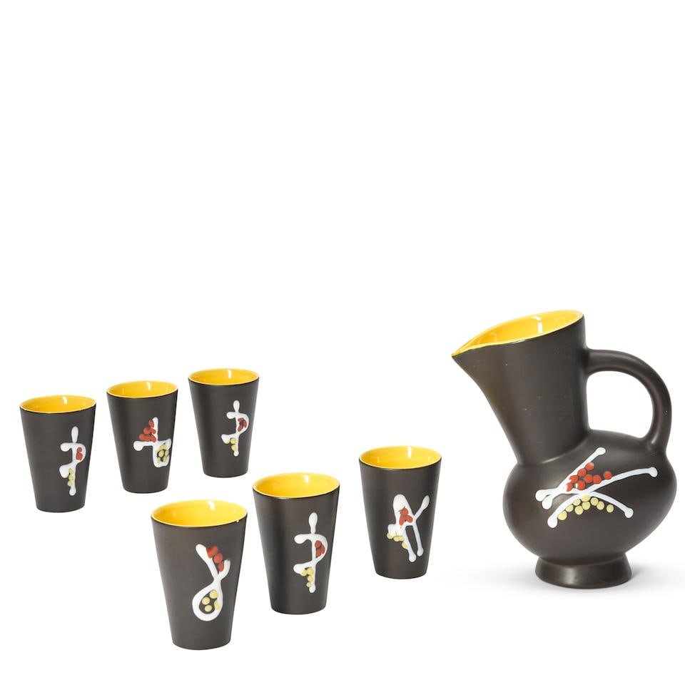 ANDRE BAUD (1903-1986) PITCHER AND SIX CUPS Vallauris, France, c. 1950, glazed ceramic with enam...: ANDRE BAUD (1903-1986) PITCHER AND SIX CUPS Vallauris, France, c. 1950, glazed ceramic with enamel decoration, all with impressed stamp mark 'Vallauris,' pitcher ht. 9 3/4, cups ht. 4 3/8 in. Footnote