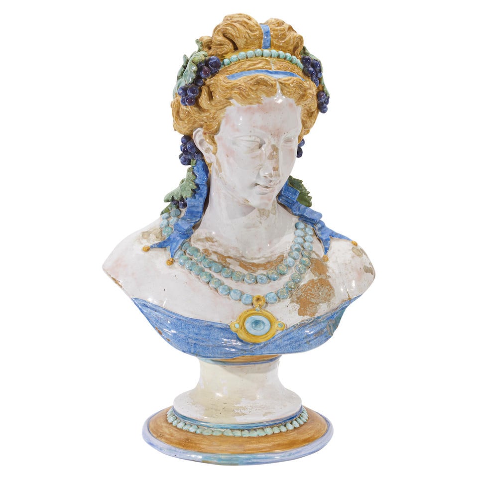 A MAJOLICA BUST OF A WOMAN ADORNED IN GRAPES20th century: A MAJOLICA BUST OF A WOMAN ADORNED IN GRAPES 20th century height overall 31in (78.8cm) Footnotes: Condition reports are not provided in catalog descriptions. The absence of a condition report does not