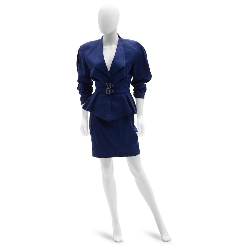 THIERRY MUGLER: BUCKLE SKIRT SUIT ENSEMBLE 1980-1990: THIERRY MUGLER: BUCKLE SKIRT SUIT ENSEMBLE 1980-1990 • Purple Wool Exterior • Double Buckle Detail at Waist • Snap Button Closure • Size Marked 38 Footnotes: OVERALL CONDITION: