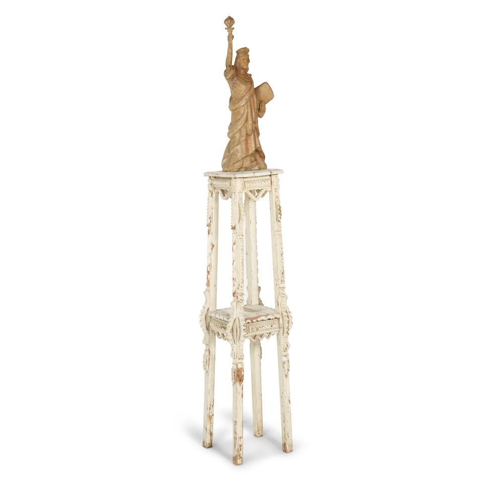 A FOLK ART CARVED WOOD FIGURE OF THE STATUE OF LIBERTY ON AN INTEGRATED WHITE PAINTED STANDEarly... (1 of 1)
