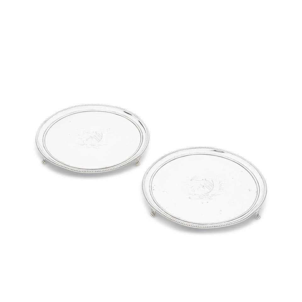 A pair of George III silver salvers Daniel Smith & Robert Sharp, London 1784, no duty mark (2): A pair of George III silver salvers Daniel Smith & Robert Sharp, London 1784, no duty mark Circular form with bead rims, on three part fluted bracket feet, centred with an engraved shield armorial, d