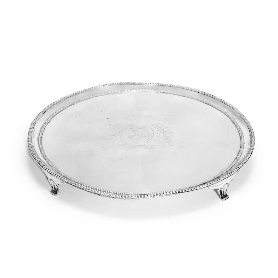 A George III silver salver Daniel Smith & Robert Sharp, London 1785, with incuse duty mark: A George III silver salver Daniel Smith & Robert Sharp, London 1785, with incuse duty mark Circular form with bead rims, on three part fluted tapering bracket feet, centred with an engraved shield ar