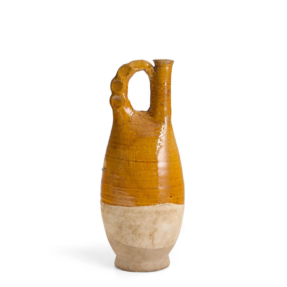 AN AMBER-GLAZED POTTERY FLASK Liao dynasty: AN AMBER-GLAZED POTTERY FLASK Liao dynasty 12 1/4in (31.2cm) high Footnotes: 遼 黃釉單把壺 Provenance: The Alan and Simone Hartman Collection 來源ᦂ