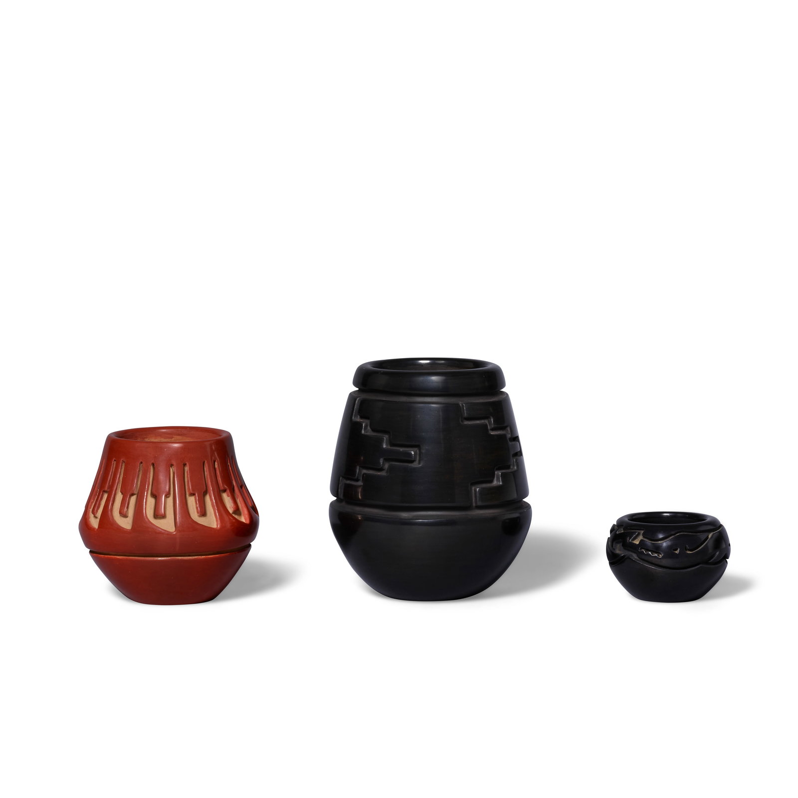 Three Santa Clara pottery jars: Three Santa Clara pottery jars Each carved with distinct decorative motifs, including: a redware feather motif jar by Teresita Naranjo (1919-1999); and two blackware jars by Toni Roller (b. 1935), the