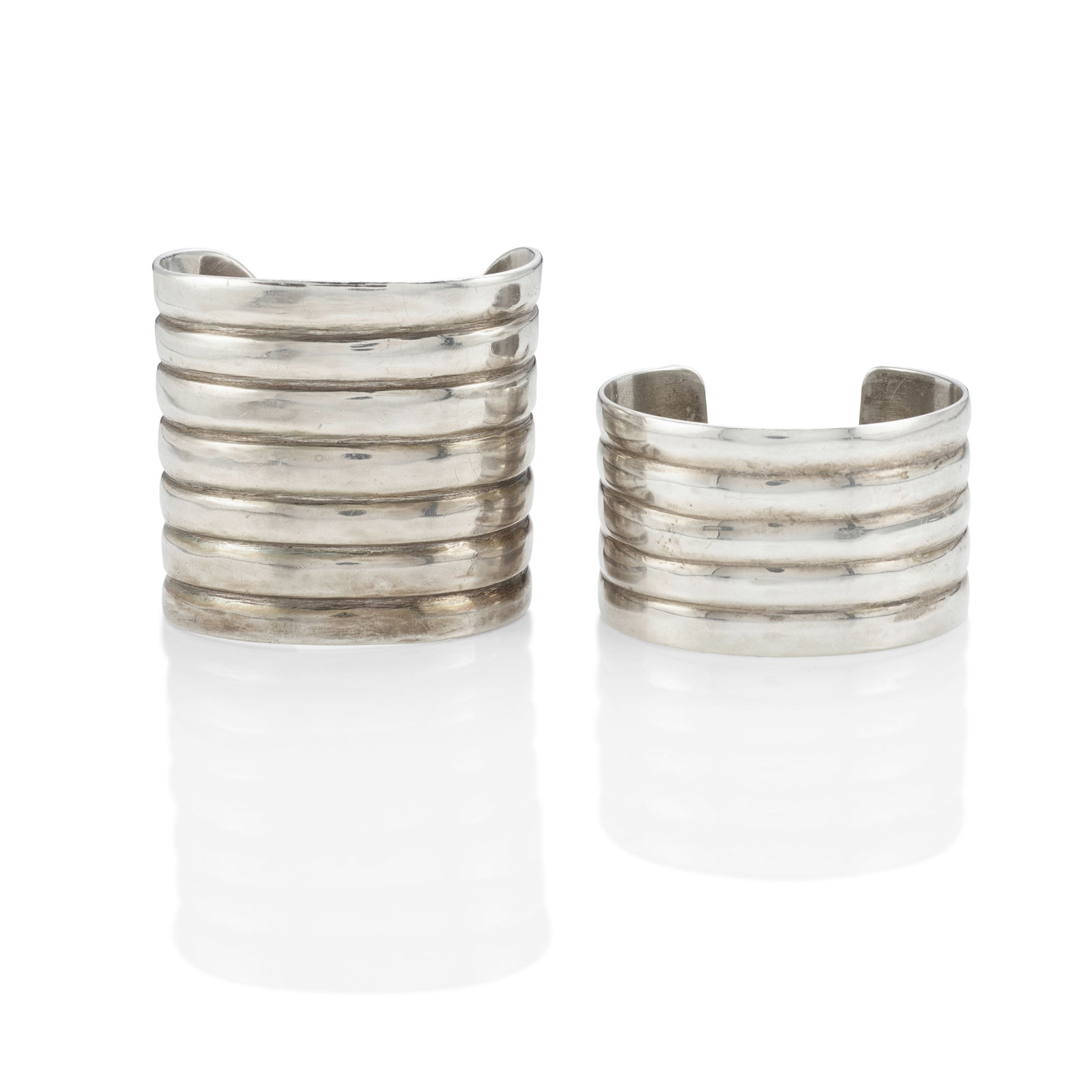 Two Patania Family sterling silver 'Georgia' cuff bracelets: Frank Patania Sr. and Sam F. Patania American, (1899-1964 and b.1959), two 'Georgia' sterling silver cuff bracelets: including a 7-ribbed example, Frank Patania Sr., gently tapered with demilune termi