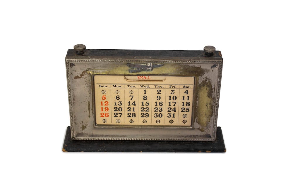 A scroll down metal calendar, emblazoned with an early aircraft, circa 1905,: A scroll down metal calendar, emblazoned with an early aircraft, circa 1905, once plated alloy metal calendar with scrolling dates and months at the twist of a knob. Lot to be sold without reserve. Fo