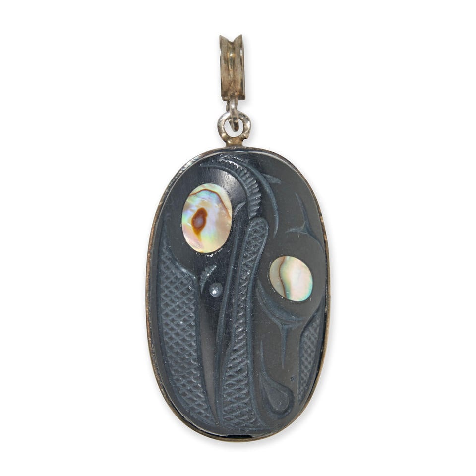 CONTEMPORARY NORTHWEST COAST SILVER AND ARGILLITE PENDANT lg. 1 1/2, wd. 1 in.: CONTEMPORARY NORTHWEST COAST SILVER AND ARGILLITE PENDANT A double-sided inlaid argillite pendant, each side with the head and wing of a bird on a hachured ground, including a heron and raven, pierced