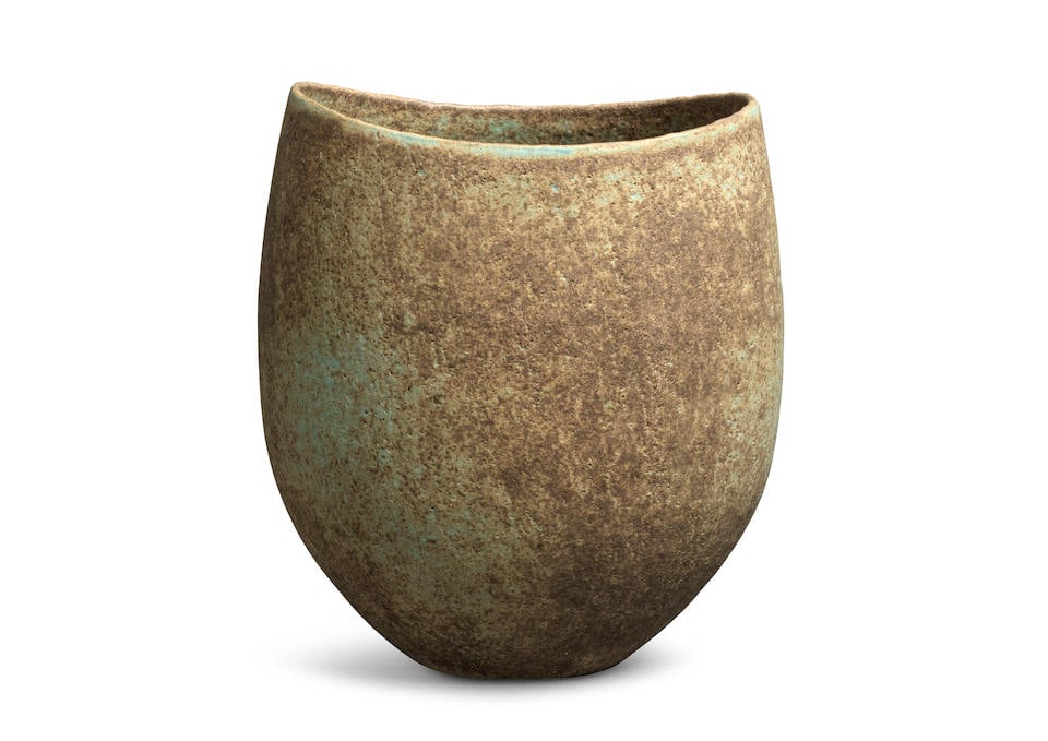 John Ward (British, 1938-2023) Small pot, circa 1980: John Ward (British, 1938-2023) Small pot, circa 1980 Stoneware, mottled green and brown glazes over a softly pitted surface, flattened oval form with dipped rim. 14 cm high, 12 cm wide, 9.3 cm deep Un