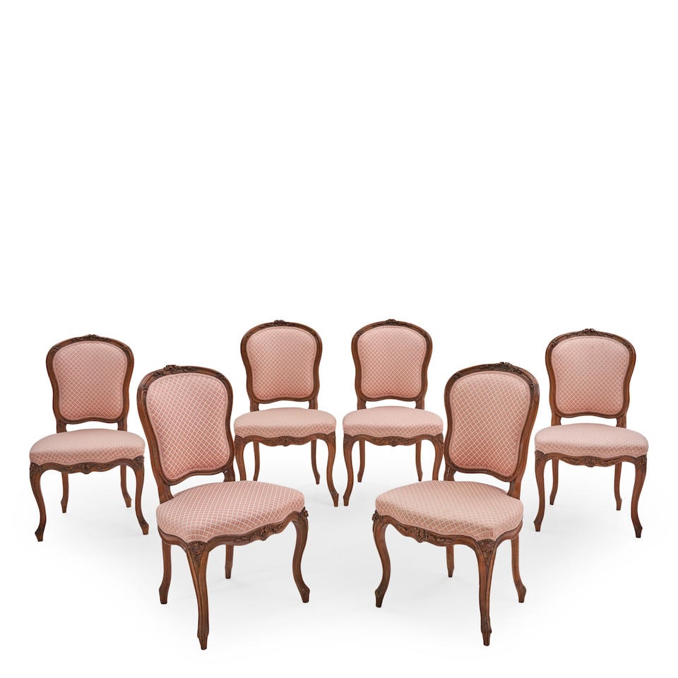Six Louis XV Provincial Side Chaises, France, mid-18th century,: Six Louis XV Provincial Side Chaises, France, mid-18th century, beechwood, the cartouche-form padded back with floral crest above a channeled frame, the serpentine seat with similarly carved apron, on