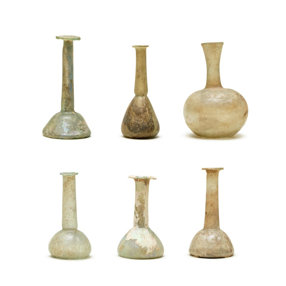Six Roman glass vessels 6: Six Roman glass vessels Circa 1st-4th century A.D. Comprising five unguentaria and a funnel necked flask 13cm-17cm high (6) Footnotes: Provenance: Some glass with old collection labels: Cesnola Colle