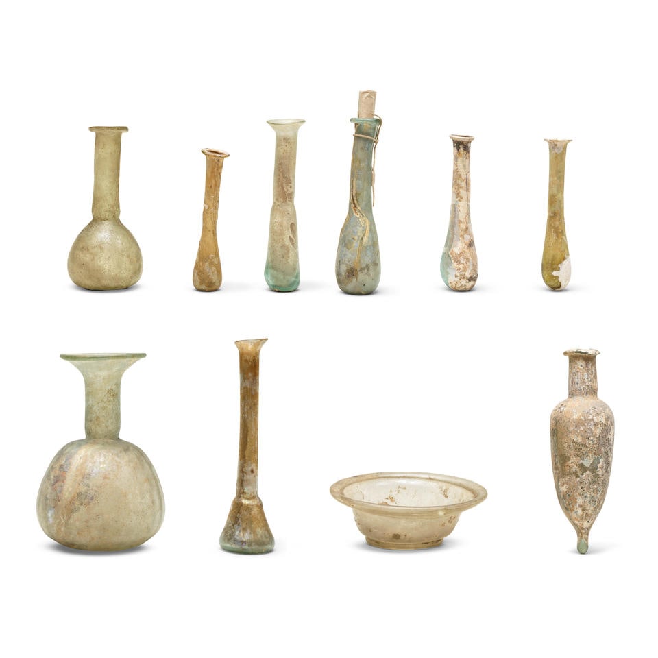 A Roman glass bowl, a phial, seven unguentaria and a bottle 10: A Roman glass bowl, a phial, seven unguentaria and a bottle Circa 1st-4th Century A.D. Bowl: 10cm diam.; Vessels: 8.5cm-13.5cm high (10) Footnotes: Provenance: Some glass with old collection labels: C
