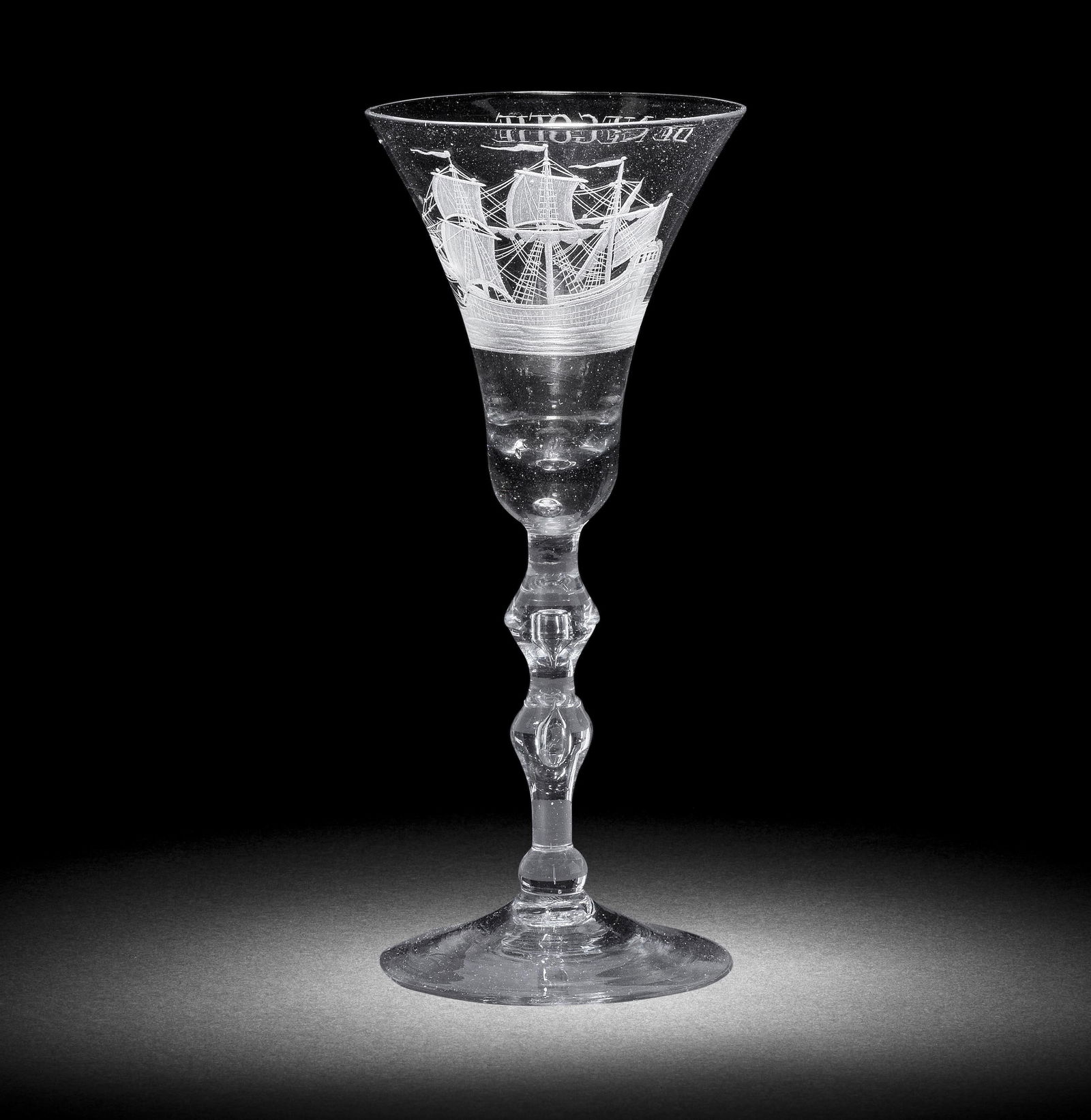 A Dutch engraved light baluster wine glass, circa 1750-60: A Dutch engraved light baluster wine glass, circa 1750-60 The flared bell bowl with a solid base containing a small tear, decorated with a three-masted ship in full sail on an undulating sea, the reve