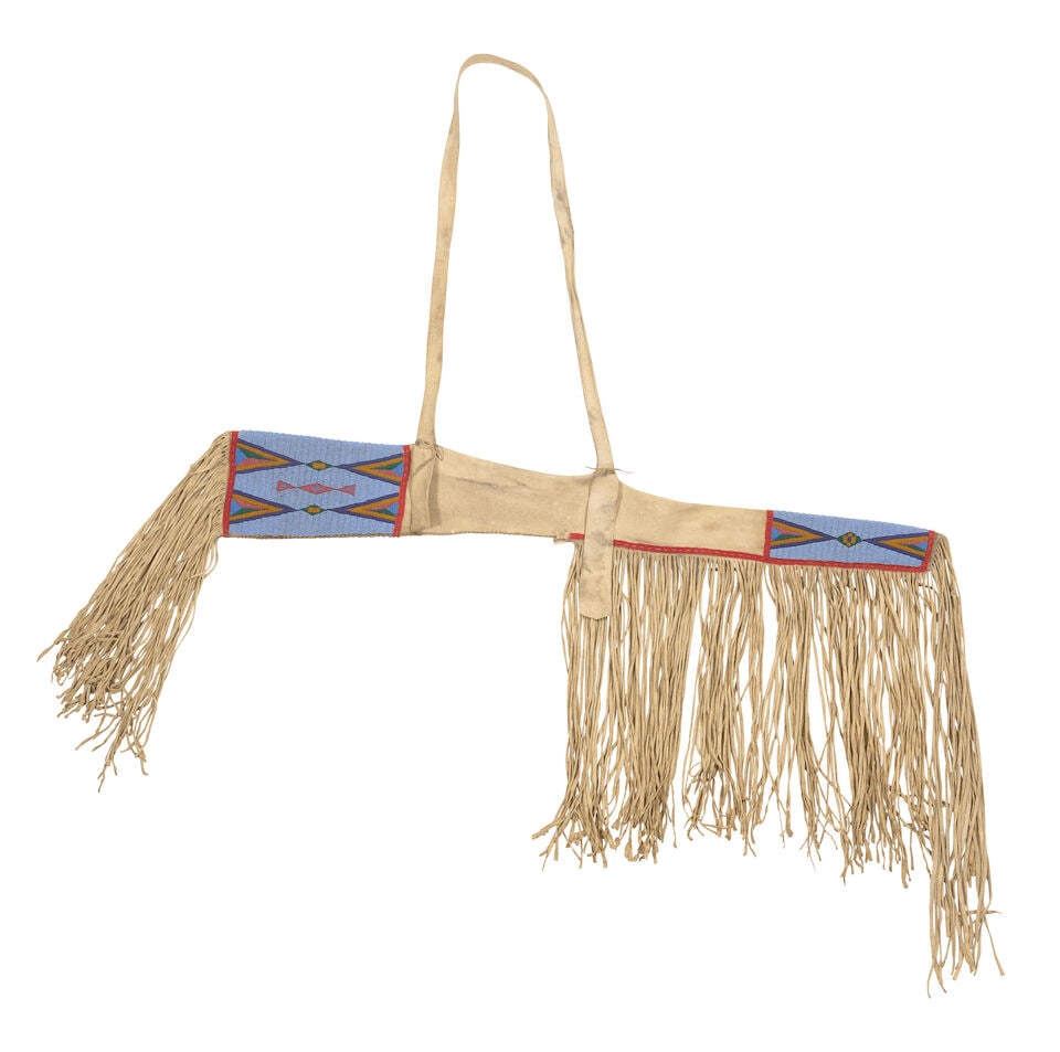 A Plateau beaded rifle scabbard: A Plateau beaded rifle scabbard First quarter 20th century, of hide construction with red wool accents, beaded in panels about the opening and end with geometric motifs, lengthy fringe at the opening