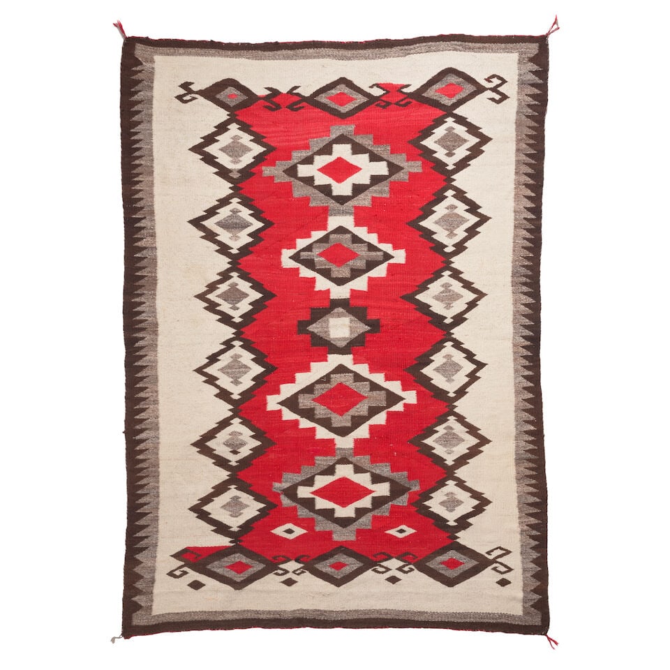 A Diné (Navajo) rug: A Diné (Navajo) rug Designed with a geometric arrangement of concentric diamonds on a red and cream ground. size approximately 6ft 10in x 4ft 10in For further information on this lot please visit