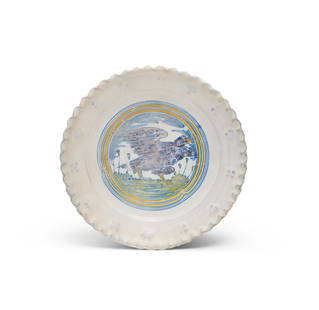 A rare Dutch maiolica dish (noppenbordje), Haarlem, circa 1600-1610: A rare Dutch maiolica dish (noppenbordje), Haarlem, circa 1600-1610Decorated with a medallion of an eagle in a landscape surrounded by blue and yellow line borders, the pie-crust rim moulded with