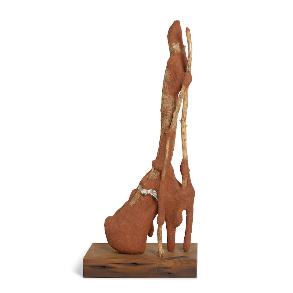 WANGECHI MUTU (B. 1972) Heeler X 25 x 6 x 9 1/2 in (63.5 x 15 x 24 cm) (Executed in 2016. This w...: WANGECHI MUTU (B. 1972) Heeler X red soil, acrylic shoes, paper pulp, wood glue, rocks, and wood 25 x 6 x 9 1/2 in (63.5 x 15 x 24 cm) Executed in 2016. This work is unique Footnotes: Provenance Glads