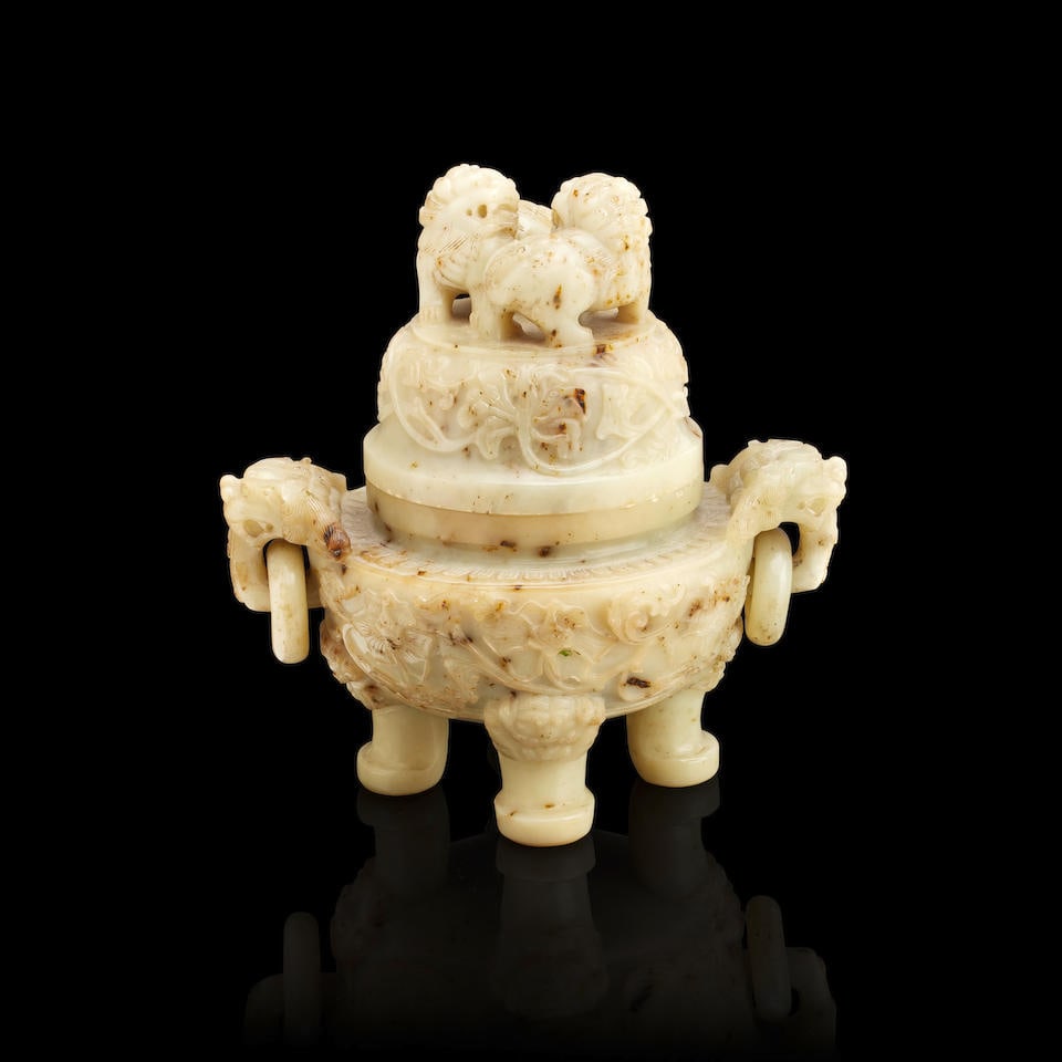 A Chinese carved stone censer Republic or later: A Chinese carved stone censer Republic or later Of bottled of mottled celadon colour and standing on three legs, the body of squat circular form and carved in relief with scrolls and flowers with drag