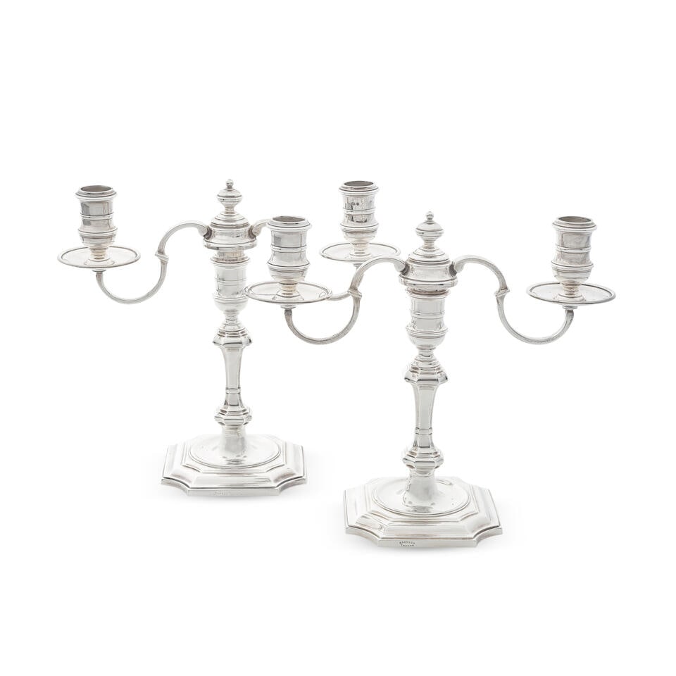 A pair of cast silver two-light candelabra probably John Charles Lowe, London 1958: A pair of cast silver two-light candelabra probably John Charles Lowe, London 1958 In the Queen Anne style, the detachable branch sections with scroll arms and central finial, knopped columns on shap