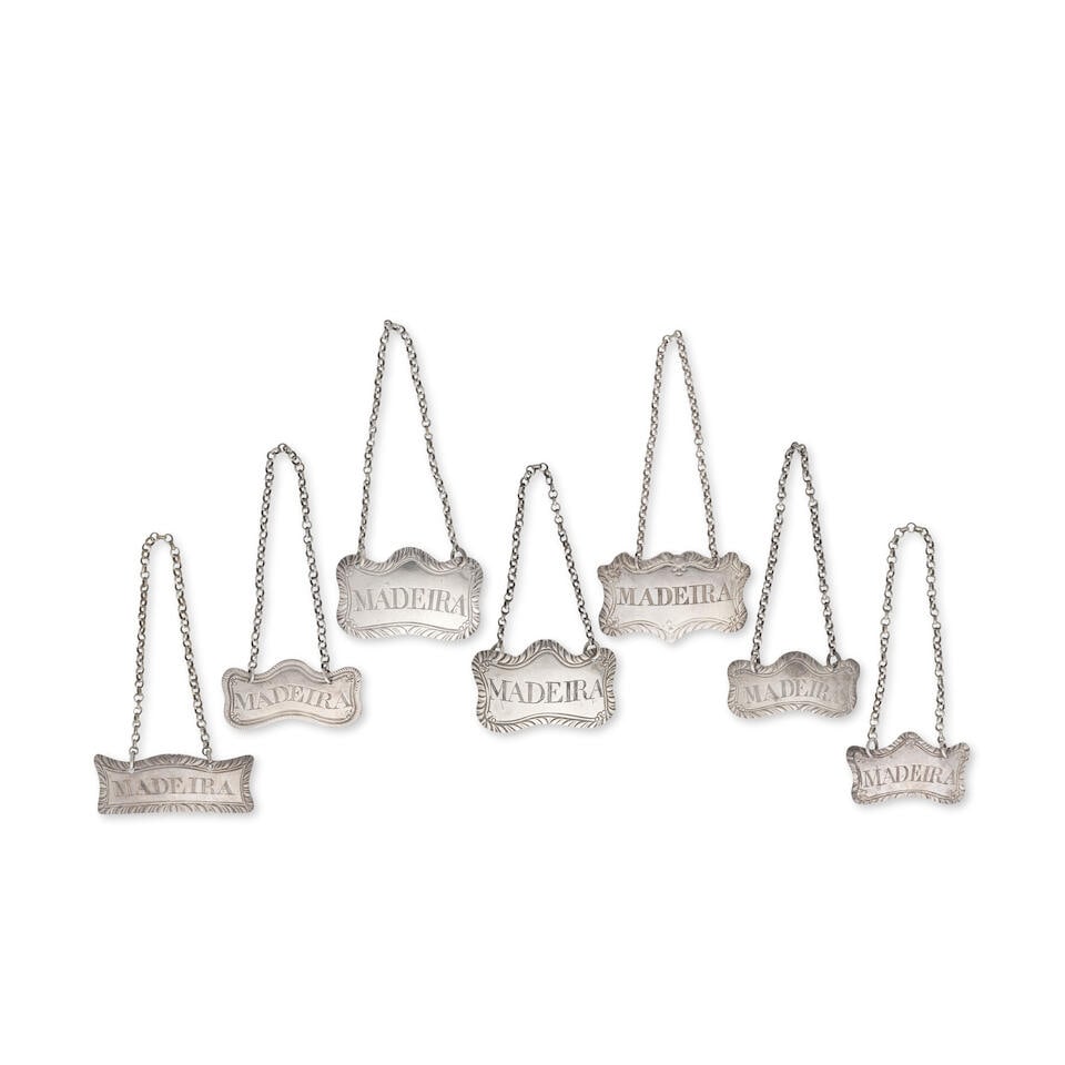 A collection of seven silver MADEIRA labels all Margaret Binley, London, circa 1780 (7): A collection of seven silver MADEIRA labels all Margaret Binley, London, circa 1780 Shaped-rectangular, scroll cushion form, feather edge borders, with incised titles, comprising: A George III label,